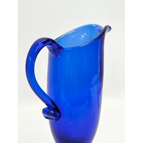 527 - An Early 20th Century Bristol Blue glass jug. 11x17.5cm.