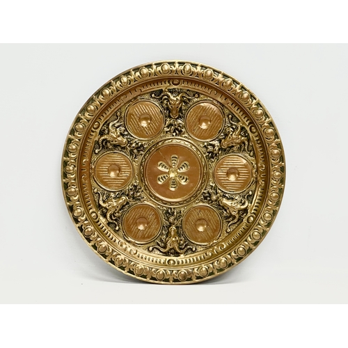 234 - A Late 19th/Early 20th Century brass serving tray with embossed rams heads and sunburst centre. 28cm