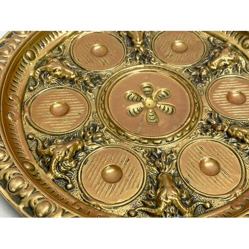 234 - A Late 19th/Early 20th Century brass serving tray with embossed rams heads and sunburst centre. 28cm