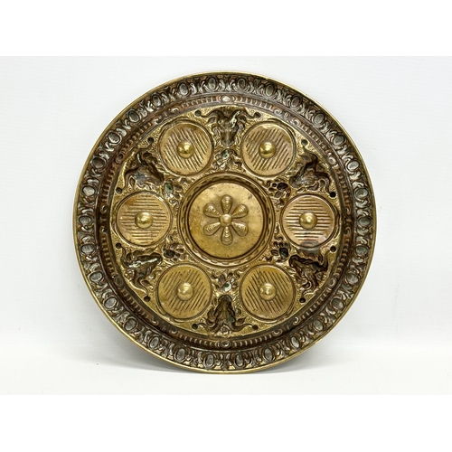 234 - A Late 19th/Early 20th Century brass serving tray with embossed rams heads and sunburst centre. 28cm