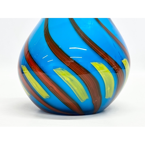 334 - A heavy art glass vase. With coloured swirls on a blue ground. 17x24cm.