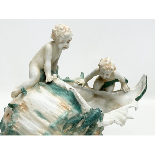 236 - A Late 19th/Early 20th Century lustre conch shell bowl, with 2 playing putti’s and lobster. 22x14x18... 