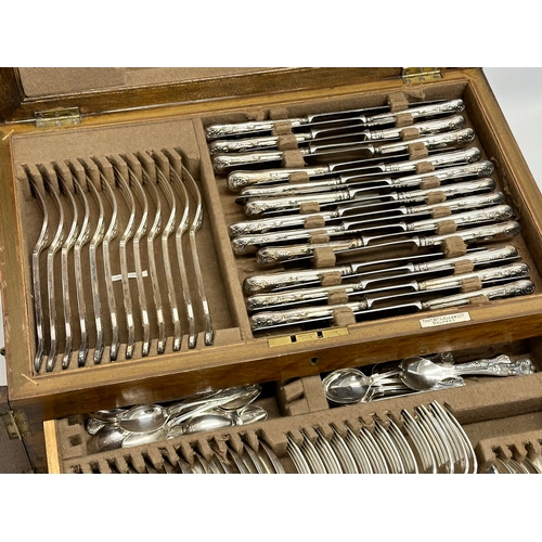 97 - Walker & Hall. A large Early 20th Century oak cased canteen of cutlery. Retailed by Thomas McLellan ... 