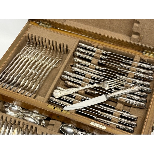 97 - Walker & Hall. A large Early 20th Century oak cased canteen of cutlery. Retailed by Thomas McLellan ... 