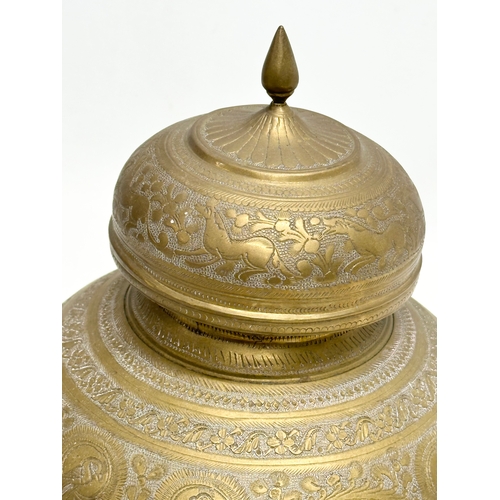 288 - A Late 19th Century Indian engraved brass jar with cover. 18x22cm.