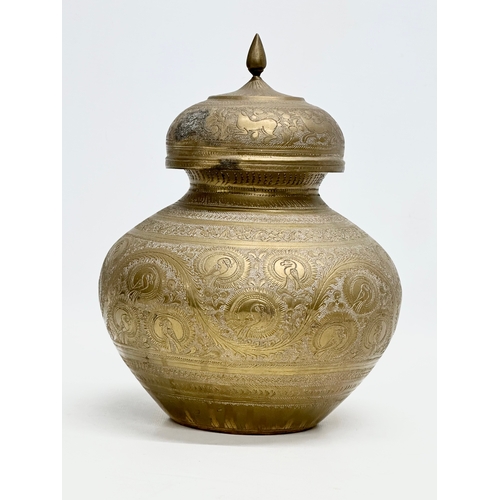 288 - A Late 19th Century Indian engraved brass jar with cover. 18x22cm.