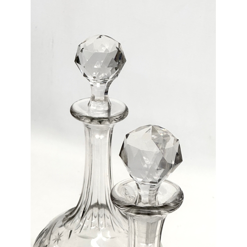 215 - A pair of 19th Century Victorian glass decanters with star cut bowls. 30cm. 28cm.