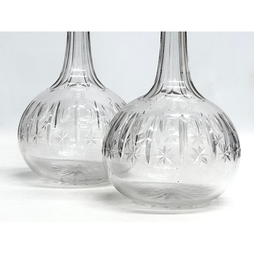 215 - A pair of 19th Century Victorian glass decanters with star cut bowls. 30cm. 28cm.