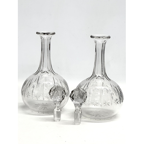 215 - A pair of 19th Century Victorian glass decanters with star cut bowls. 30cm. 28cm.