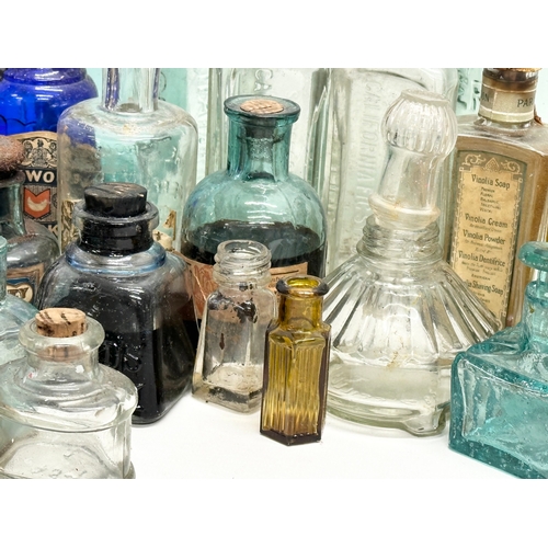 523 - A large collection of 19th and 20th Century glass bottles and jars. Chemist, ink, whiskey etc.