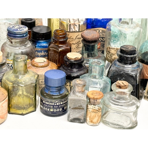 523 - A large collection of 19th and 20th Century glass bottles and jars. Chemist, ink, whiskey etc.