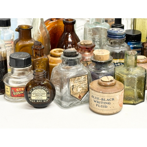 523 - A large collection of 19th and 20th Century glass bottles and jars. Chemist, ink, whiskey etc.