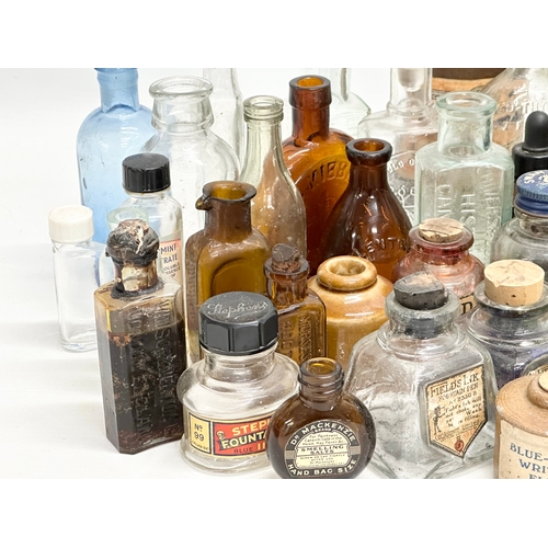 523 - A large collection of 19th and 20th Century glass bottles and jars. Chemist, ink, whiskey etc.