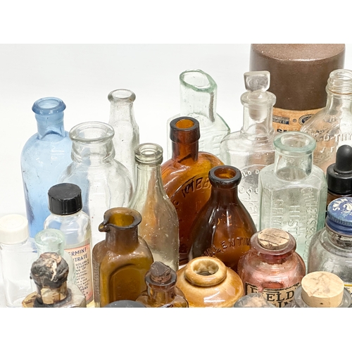 523 - A large collection of 19th and 20th Century glass bottles and jars. Chemist, ink, whiskey etc.