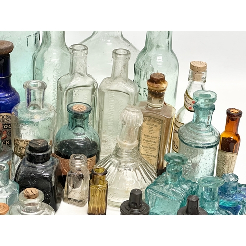 523 - A large collection of 19th and 20th Century glass bottles and jars. Chemist, ink, whiskey etc.