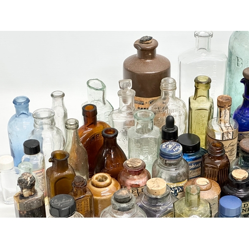 523 - A large collection of 19th and 20th Century glass bottles and jars. Chemist, ink, whiskey etc.