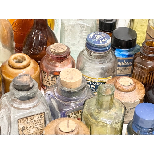 523 - A large collection of 19th and 20th Century glass bottles and jars. Chemist, ink, whiskey etc.