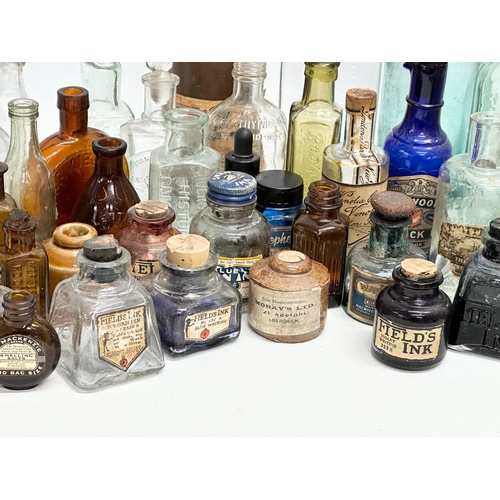 523 - A large collection of 19th and 20th Century glass bottles and jars. Chemist, ink, whiskey etc.