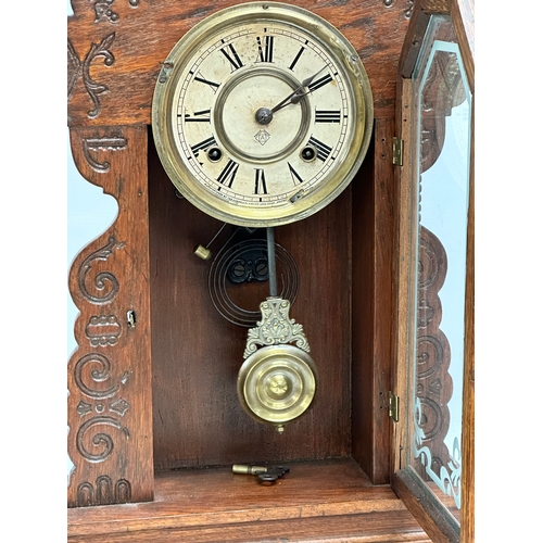 799 - A Late 19th Century American Gingerbread clock. Arsonia. With key and pendulum. 36x13x58cm