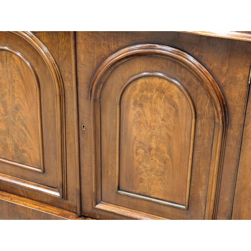 486 - A 19th Century Mid Victorian mahogany sideboard with large ogee drawer and 2 arched panel doors. 125... 