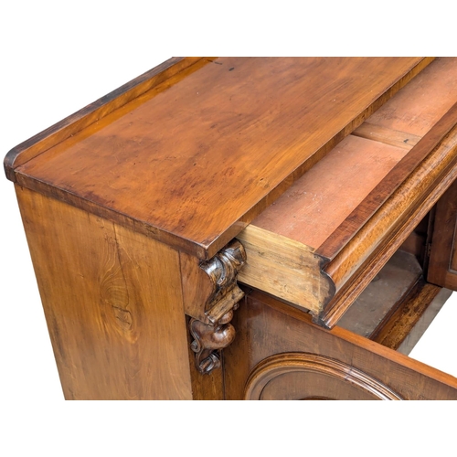 486 - A 19th Century Mid Victorian mahogany sideboard with large ogee drawer and 2 arched panel doors. 125... 