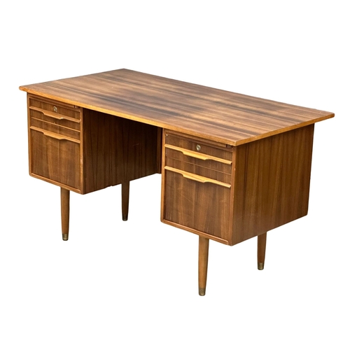 153 - A Mid Century afromosia desk. 130x69x74cm