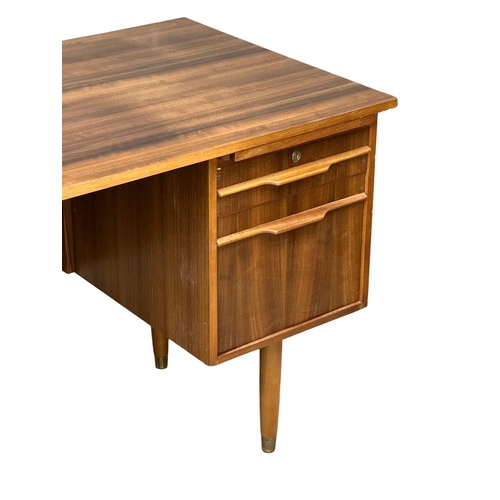 153 - A Mid Century afromosia desk. 130x69x74cm