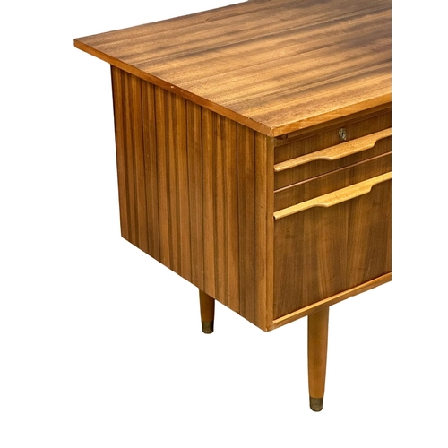 153 - A Mid Century afromosia desk. 130x69x74cm