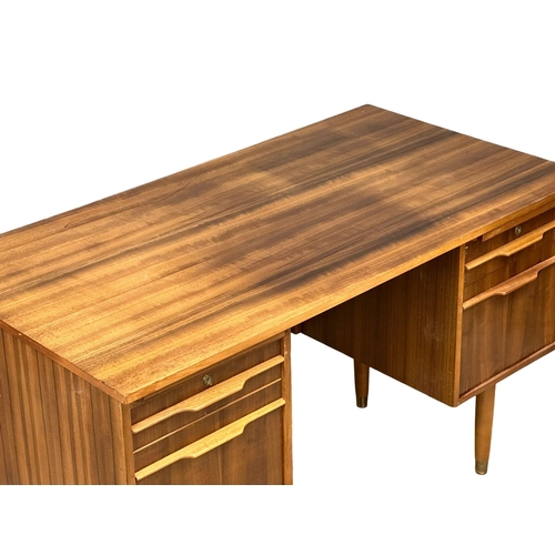 153 - A Mid Century afromosia desk. 130x69x74cm