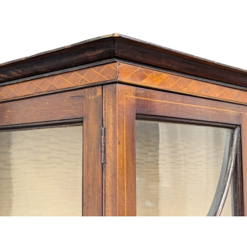 312 - An Edwardian inlaid mahogany display cabinet with bow front panel. 109x34x174cm. (5)