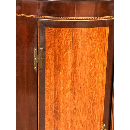 386 - A Late 18th Century George III inlaid mahogany wall hanging corner cupboard, with oak panel doors an... 