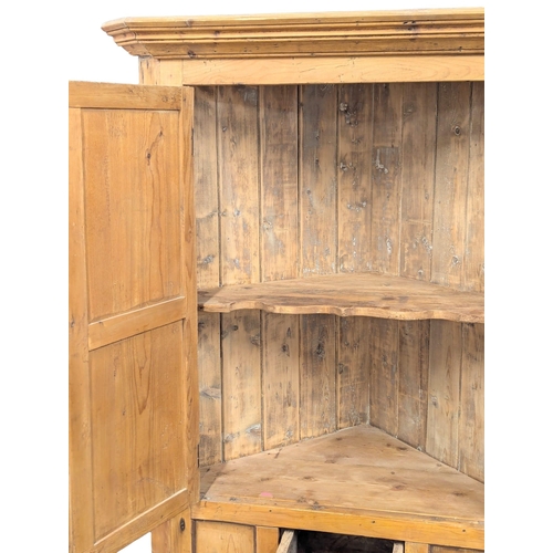 472 - A large Early 19th Century George III pine corner cabinet. 106x193cm