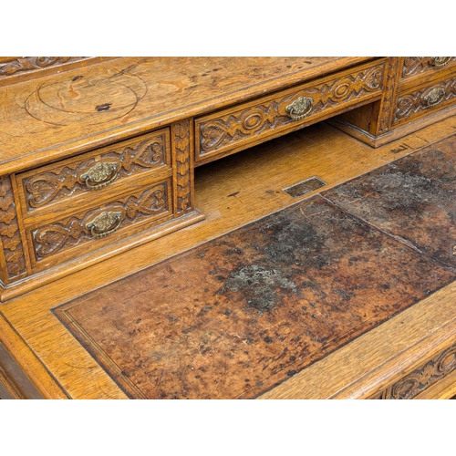 81 - A 19th Century Victorian carved oak Dickens desk. 118x69x109cm