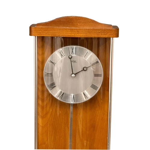 951 - A Mid Century teak wall clock. WBL. 63cm