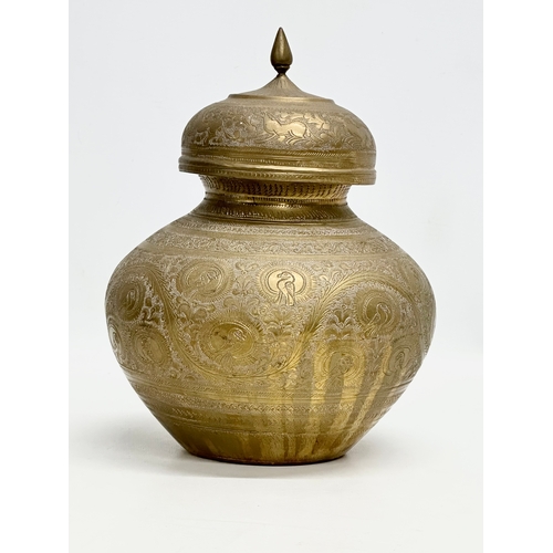 288 - A Late 19th Century Indian engraved brass jar with cover. 18x22cm.