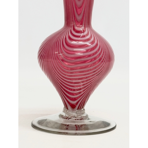 43 - A cranberry glass vase, with opalescent feathered ripples and cornet shaped rim. Italian, Empoli sty... 