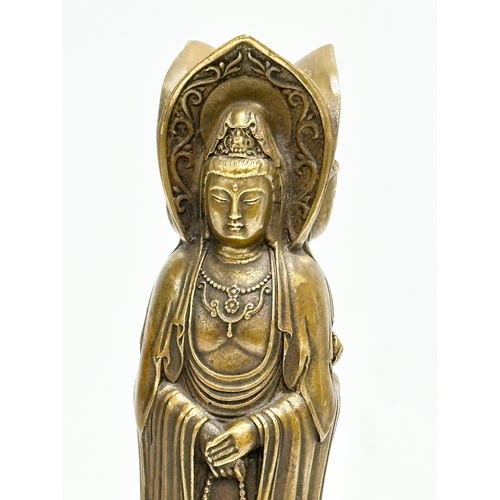 67 - A Chinese bronze 3 body Guanyin Buddha statue. Raised on a lotus leaf base. 4 character mark. 25cm