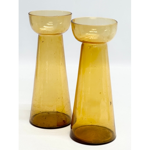 261 - Four Early 20th Century amber glass hyacinth vases. 20cm. 19.5cm. 18.5cm.