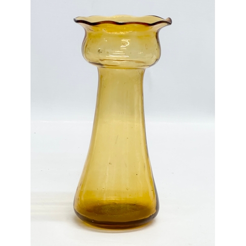 261 - Four Early 20th Century amber glass hyacinth vases. 20cm. 19.5cm. 18.5cm.