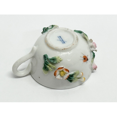 141 - Sitzendorf. A Late 19th/Early 20th Century German flower encrusted miniature cup and saucer, with pa... 