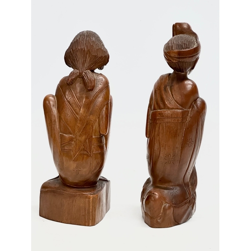 291 - A pair of Early 20th Century Balinese carved boxwood figures. 21cm