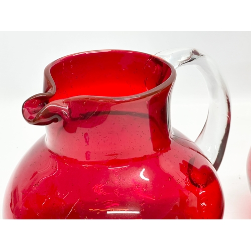 266 - A pair of large Victorian style ruby glass water jugs. 23x20x19cm.