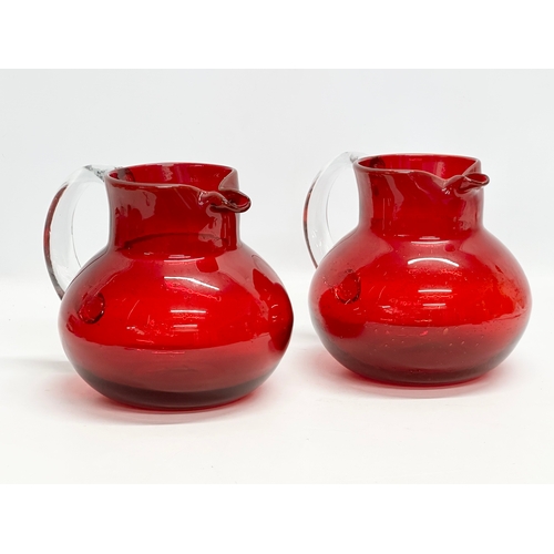 266 - A pair of large Victorian style ruby glass water jugs. 23x20x19cm.