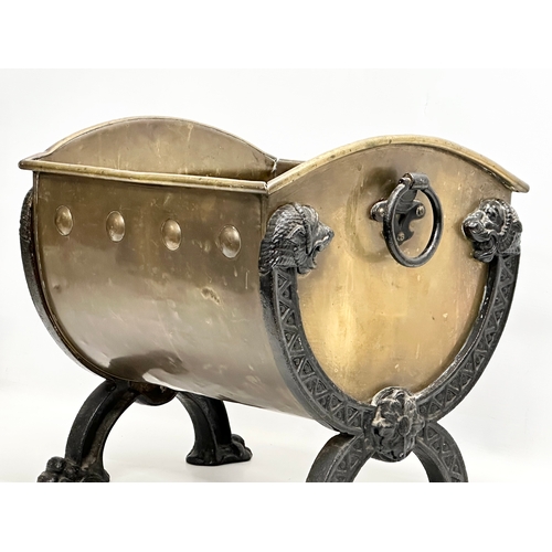 33 - A Late 19th Century Victorian brass coal bucket, with x-framed cast iron lion heads, paw feet and la... 