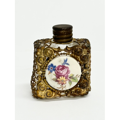 393 - A small Early 20th Century gilt brass mounted perfume bottle with porcelain panel. 4x5cm