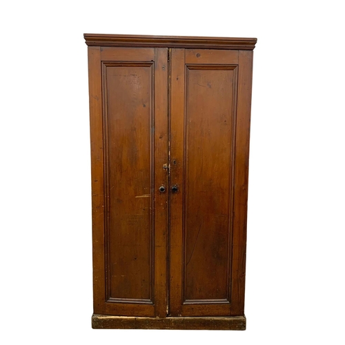 25 - A Victorian pine 2 door cupboard with fitted shelves in original scumble paint. Circa 1870. 110 x 36... 