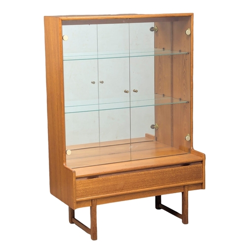 123 - A Mid Century teak display cabinet by Turnidge of London. With drawer and fitted glass shelves. 91.5... 