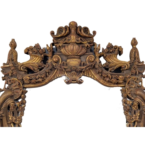 6 - A very large ornate gilt wooden framed mirror with extensive carvings. 168x256cm