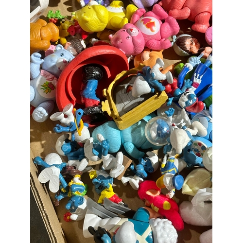 43 - A box of vintage dolls and toys. Care Bears, Smirfs etc