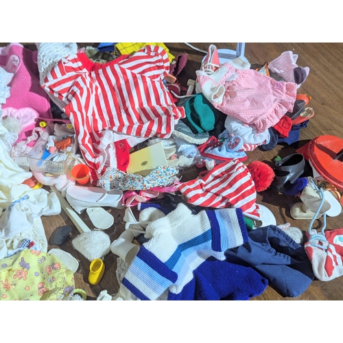 55 - A collection of vintage doll clothes, shoes, accessories, etc.